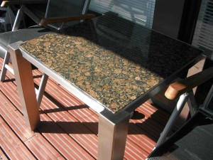ruostumattomasta teräksestä tehty puutarhapöytä graniittitasolla      